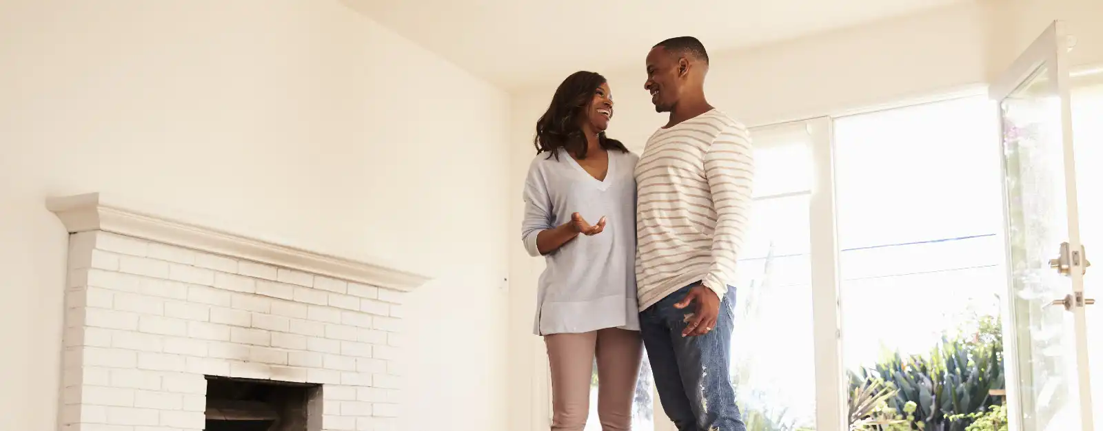 Man and woman hugging and smiling in new living room